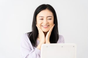 鏡を見て微笑む40代女性